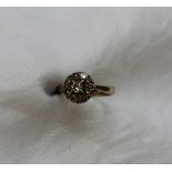 A diamond cluster ring set with a central round brilliant cut diamond approximately 0.