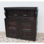 An 18th century oak court cupboard, the planked top above a carved frieze and turned columns,