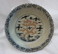 A Chinese porcelain charger with a shaped rim, the border with scrolling decoration,