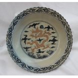 A Chinese porcelain charger with a shaped rim, the border with scrolling decoration,