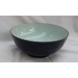 A Chinese porcelain bowl with a line decorated rim, to a royal blue ground on a pedestal foot,