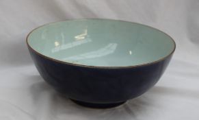 A Chinese porcelain bowl with a line decorated rim, to a royal blue ground on a pedestal foot,