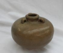 A Chinese Song dynasty stoneware three handled vase, with a green and brown glaze and unglazed base,