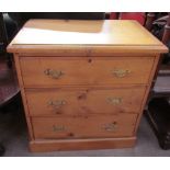 A small pine chest with a rectangular top and three drawers on a plinth base