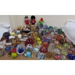 Assorted glass paperweights together with a Murano glass clown, hardstone eggs,