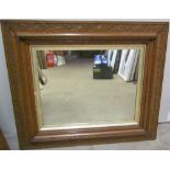 A plaster framed wood effect wall mirror