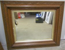 A plaster framed wood effect wall mirror