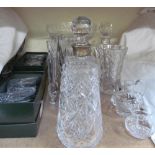 A silver topped decanter together with other glasswares
