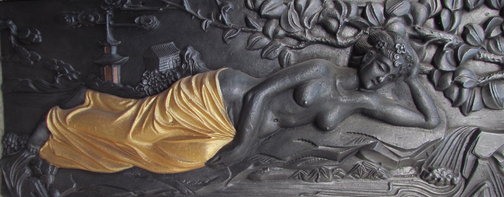 A cast iron plaque of a reclining maiden