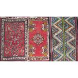 A small red ground rug, decorated with flowers and leaves,