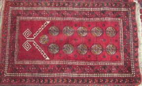 A Turkoman prayer rug with a red ground,
