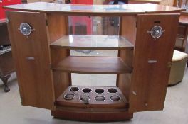 A Turnidge teak bar, with fold over top enclosing a glass top,