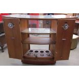 A Turnidge teak bar, with fold over top enclosing a glass top,