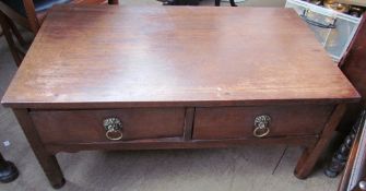 A mahogany coffee table with a pair of drawers and lions head handles on square legs