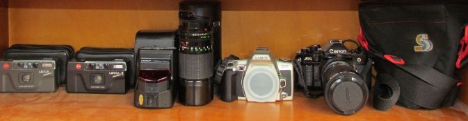 A Leica Mini 35mm camera together with a Leica Mini II, a Minolta DNYAX 505Si,