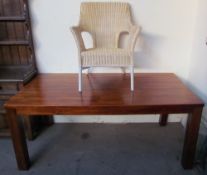 A modern refectory table together with a wicker chair