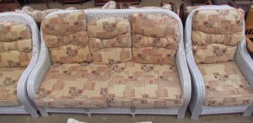 A wicker upholstered five piece suite, comprising a three seater,