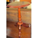 A mahogany wine table with a circular top and baluster column on three legs