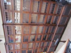 A set of three eight section oak bookcases with pairs of leaded glass doors on turned legs