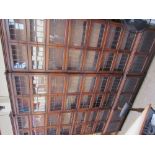 A set of three eight section oak bookcases with pairs of leaded glass doors on turned legs