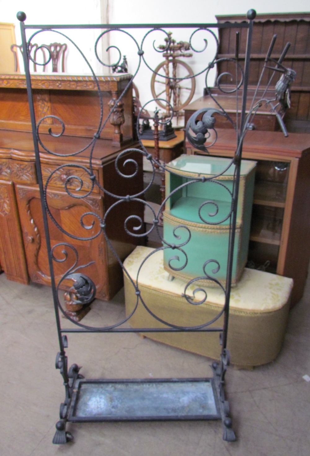 A cast iron plant stand with scrolling leaf design together with a bird on a bull rush