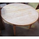 A 20th century pine table of circular form on square legs