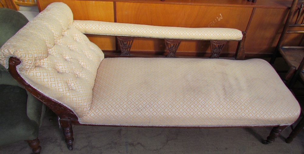 An Edwardian upholstered chaise longue on turned legs