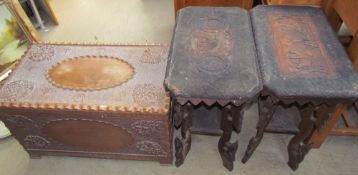 An oriental carved camphor wood coffer together with a pair of side tables carved with elephants