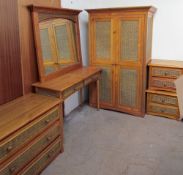 A pine and wicker bedroom suite including a single wardrobe, dressing table, wall mirror,