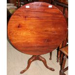A George III mahogany tripod table, with a circular top on a snap action,