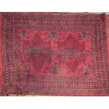 A rug with a red ground and two medallions with hooked botehs and multiple guard stripes,