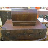 A brown leather suitcase together with a Singer sewing machine in a case