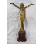 An Art Deco style gilt decorated figure of a maiden with outstretched arms on a wooden base