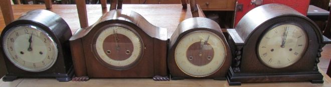 A bakelite mantle clock together with two oak mantle clocks and a walnut mantle clock