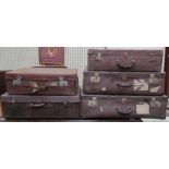 A set of three suitcases together with two leather suitcases, one bears a label,