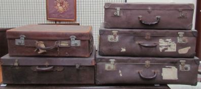 A set of three suitcases together with two leather suitcases, one bears a label,