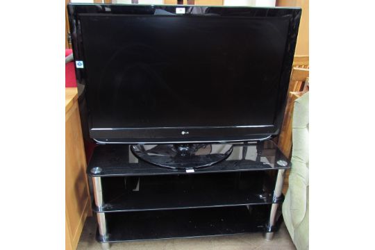 An LG 42” flat screen television on a black glass and chrome stand (Sold as seen,