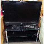 An LG 42” flat screen television on a black glass and chrome stand (Sold as seen,