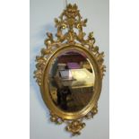 A pair of gilt decorated wall mirrors with scrolls and leaf decoration