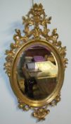 A pair of gilt decorated wall mirrors with scrolls and leaf decoration