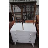 A white painted chest of drawers and a faux marble topped side table