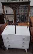 A white painted chest of drawers and a faux marble topped side table