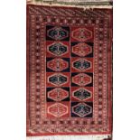 A rug with a red and blue panelled ground with twelve guls and multiple guard stripes,