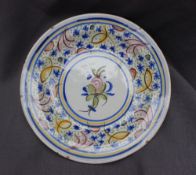 A Majolica charger, painted to the edge with flowerheads and leaves, the centre painted with fruit,