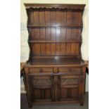 A 20th century oak dresser with a moulded cornice above a planked rack with shelves,