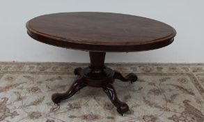 A Victorian rosewood supper table the oval top with a shallow apron,