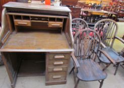 An oak tambour fronted pedestal desk together with a set of three wheel back elbow chairs