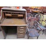 An oak tambour fronted pedestal desk together with a set of three wheel back elbow chairs