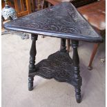 A carved oak wine table with a brass triangular table top on ring turned baluster legs,