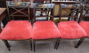 A set of eight Regency style ebonised dining chairs with gilt floral decoration and caned seats